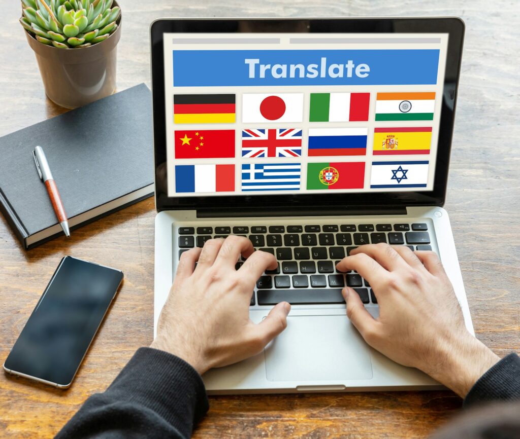 Man working on a laptop with the word translate on the computer screen